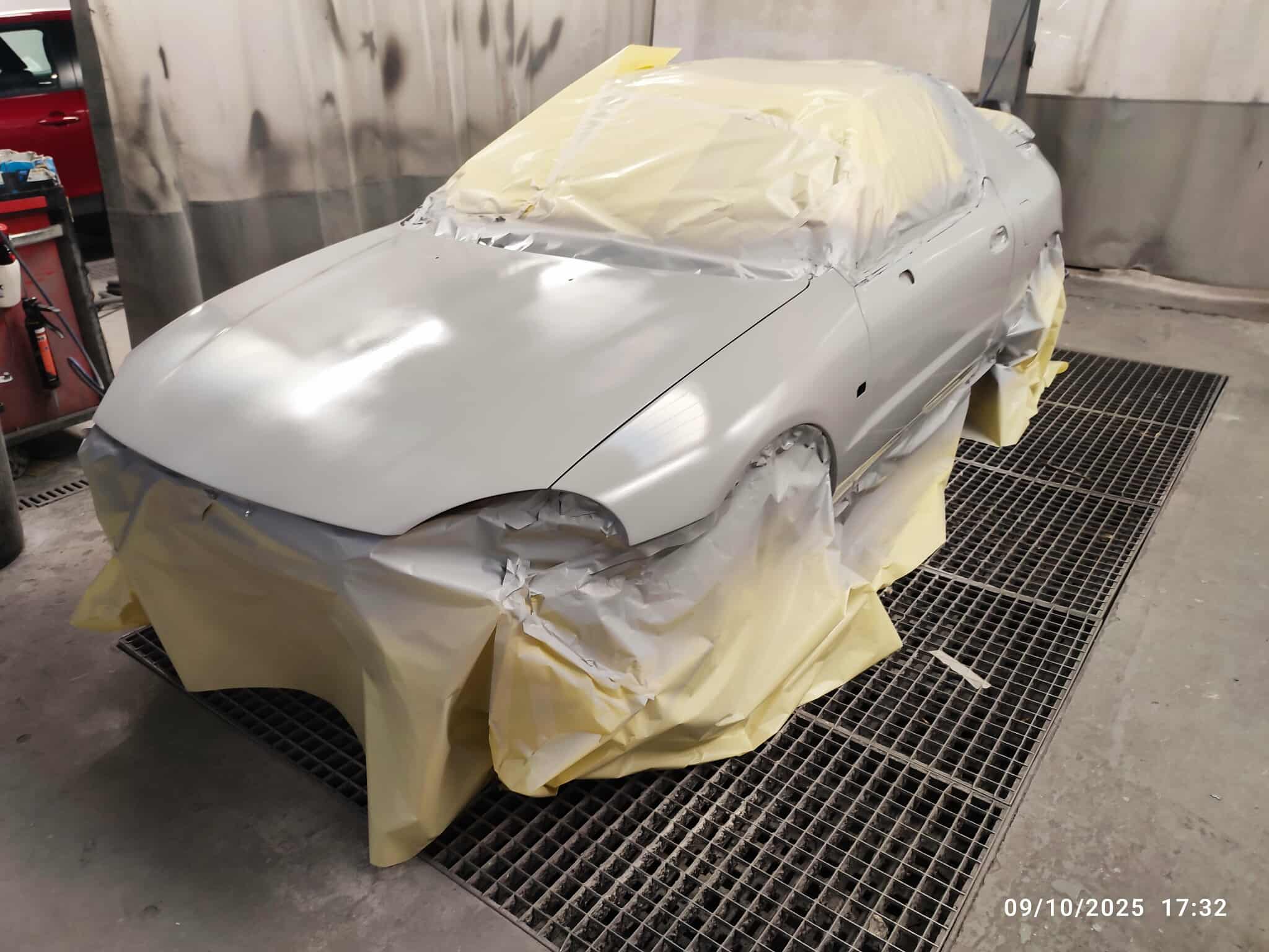 Avant – voiture entière en apprêt gris, cabine de peinture